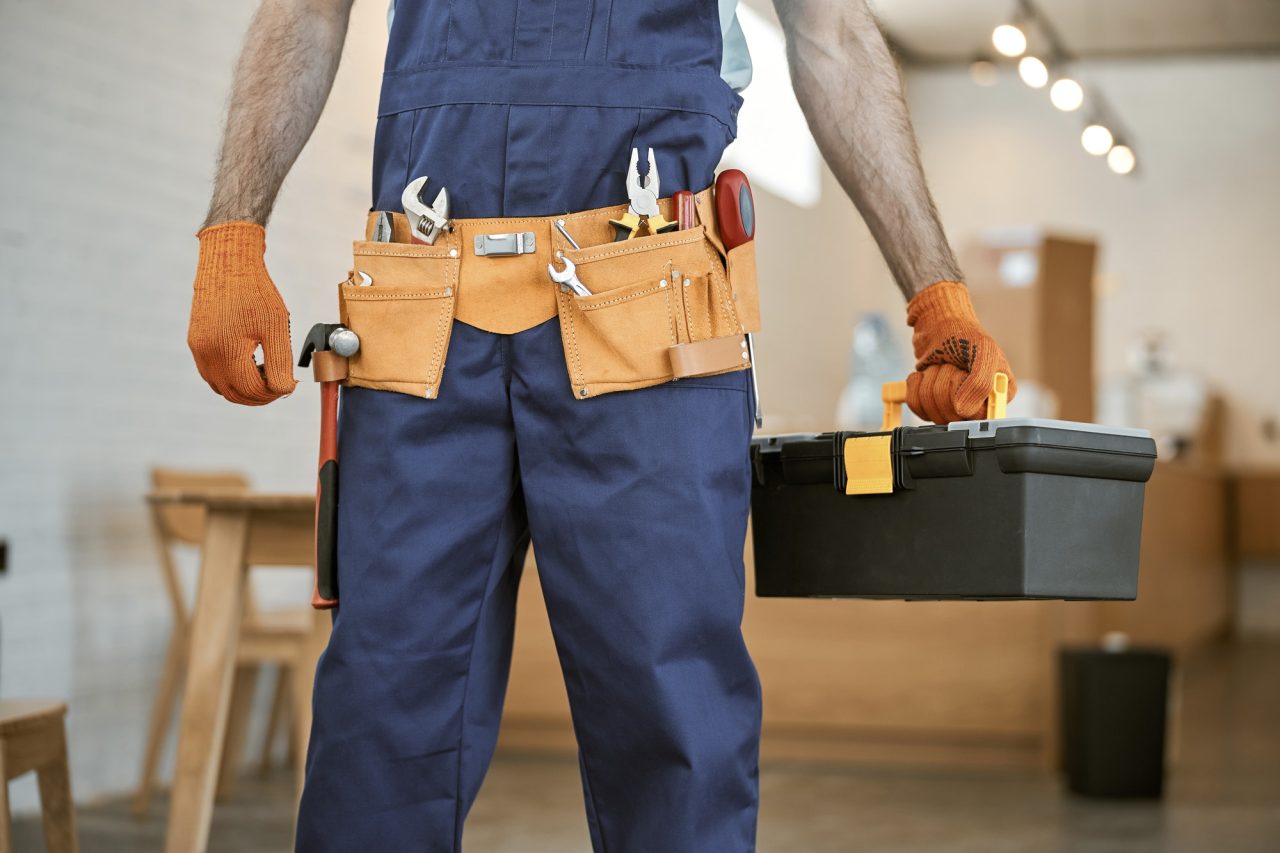 male-electrician-in-gloves-holding-tool-box-set